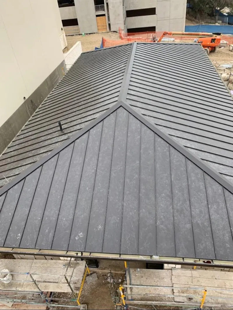 Commercial metal roof construction with crane equipment in Newbury